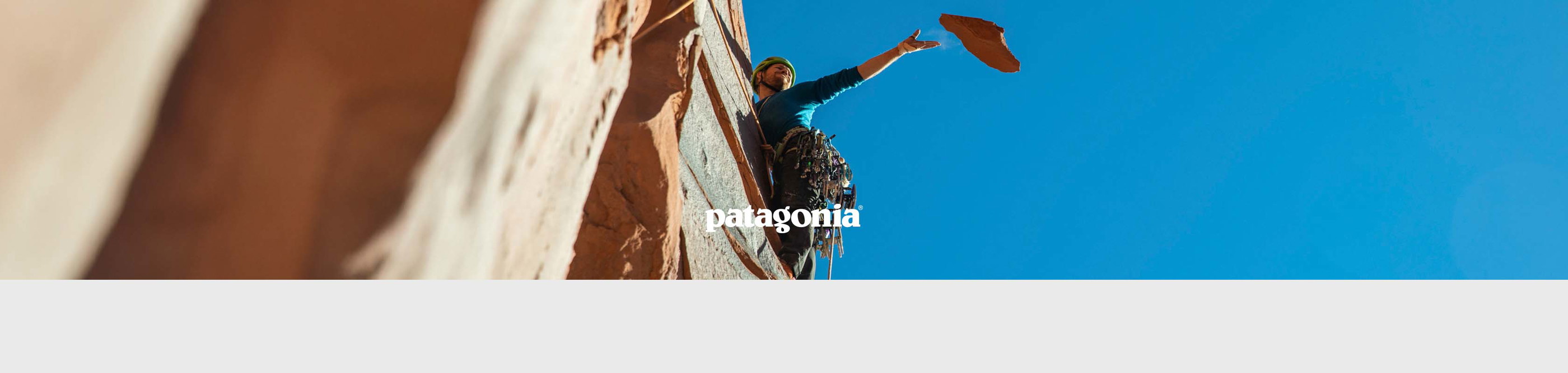Shop Patagonia collection. A man climbing a rock